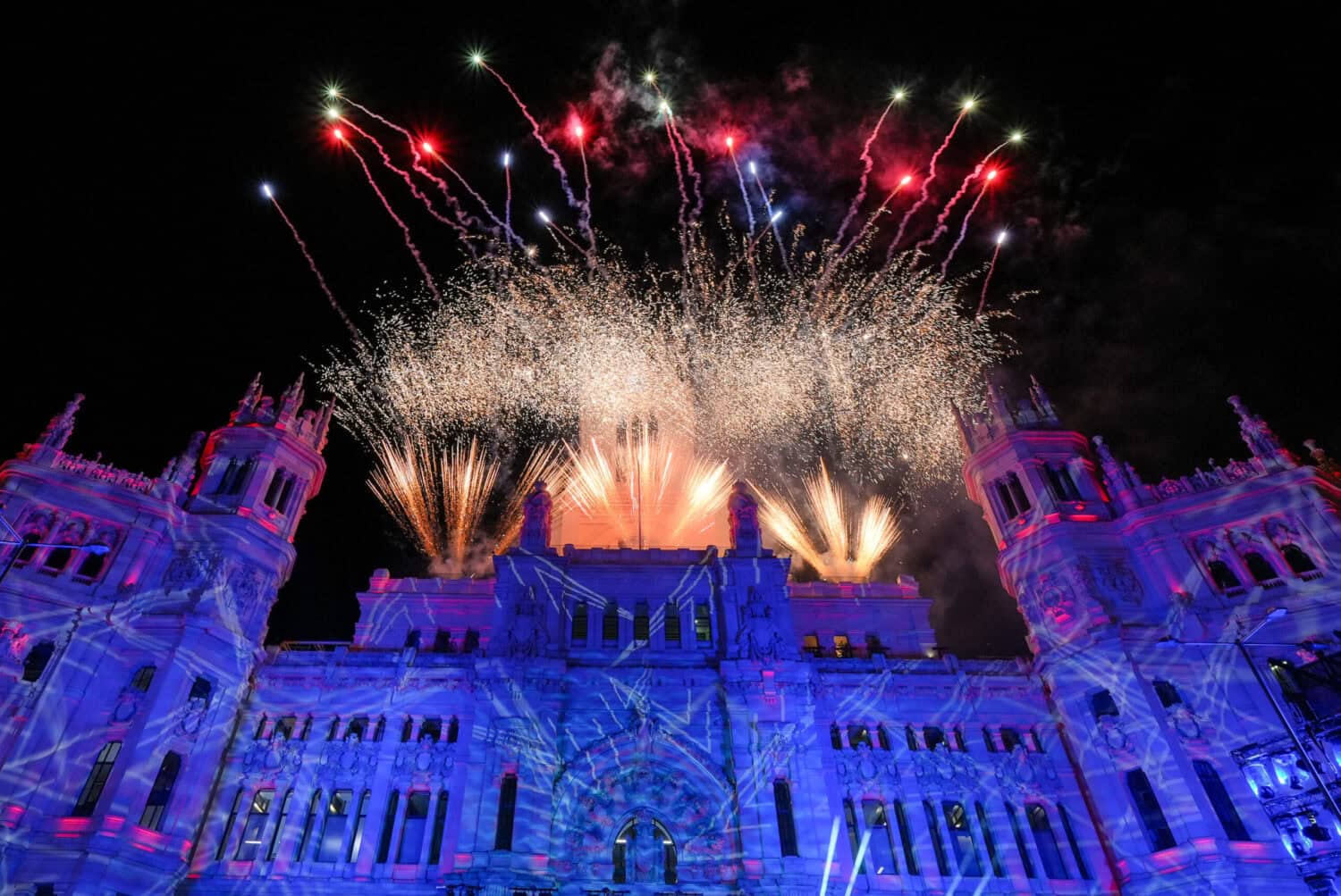 Espectacular show de fuegos artificiales iluminando el Palacio de Madrid en una noche especial.